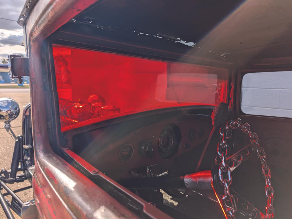 ratrod-car-windshield-with-red-window-tint Old custom hotrod with red tinted windshield viewed from inside looking out.